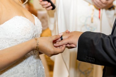 Gelin, nikah töreninde damadın parmağına yüzük takıyor. Aşkın sembolü, birlik ve ömür boyu bağlılığın romantik ve duygusal bir anda yakalanması..