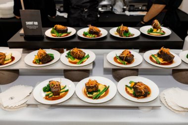 Kremalı patates püresi, gevrek yeşil fasulye ve bol soslu pirzola ile kaplanmış bir gurme sunumu. Renk, doku ve kaliteli yemek zarafeti senfonisi.