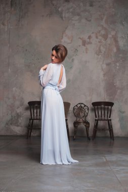 Uzun elbiseli bir kız omzunun üzerinden bakarak