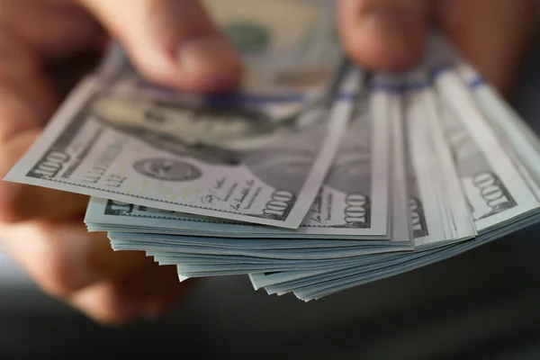 One hundred dollar bills in hands — Stock Photo, Image