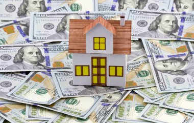Toy house on dollar bills clipart