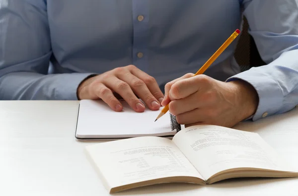 Student schrijven in een notitieblok — Stockfoto