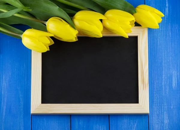 Yellow tulips and blank blackboard — Stock Photo, Image