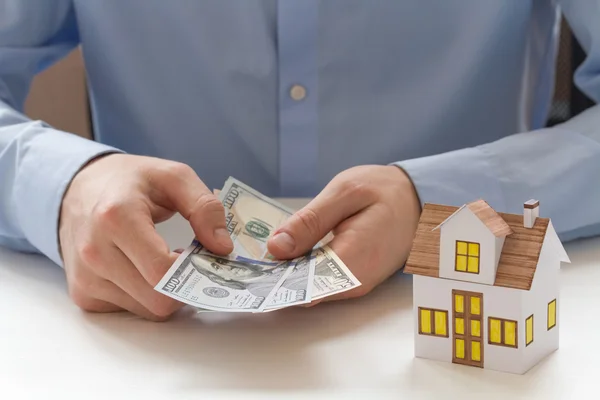 businessman holding one hundred dollar