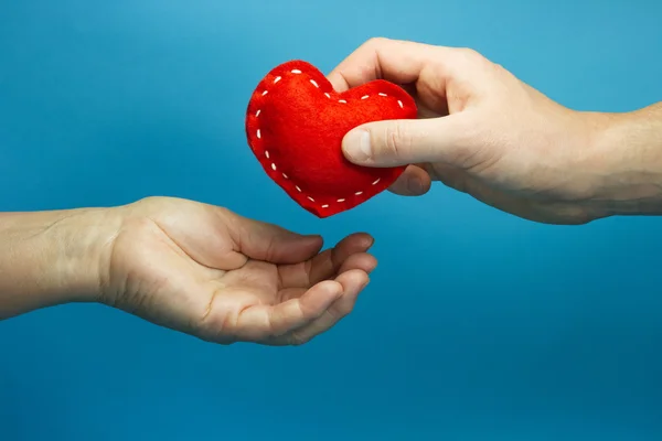 Hand legt das Herz in die Hand der Frau — Stockfoto