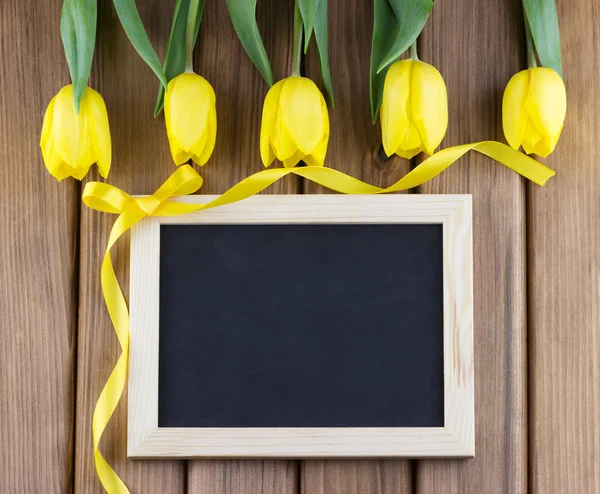 Yellow tulips and blank blackboard — Stock Photo, Image