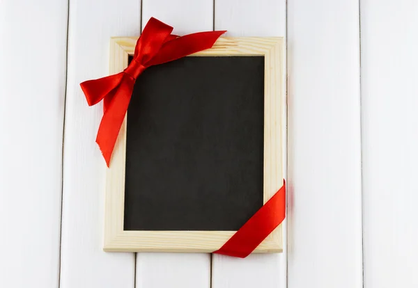 Empty blackboard decorated red bow — Stock Photo, Image
