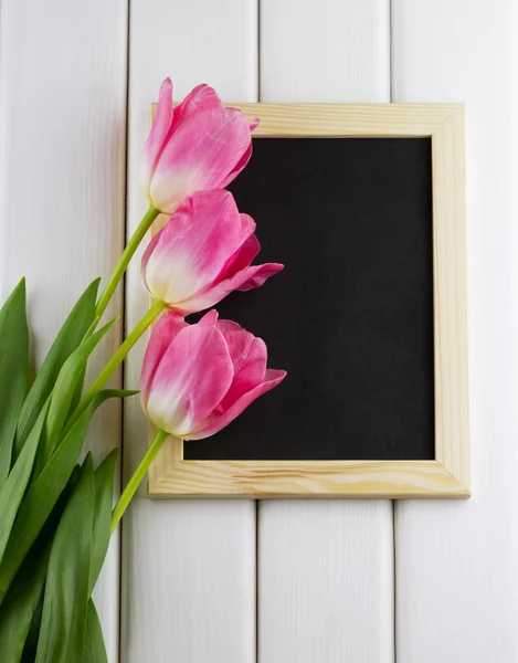 Pink tulips with empty blackboard — Stock Photo, Image