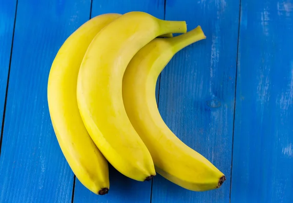 Bananas amarelas em azul — Fotografia de Stock