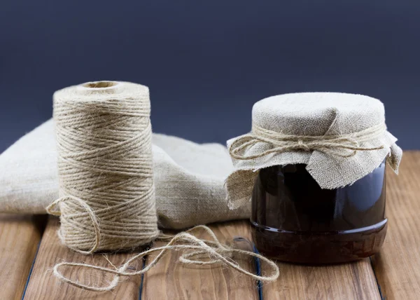 Glass jar of jam with twine — Stock Photo, Image