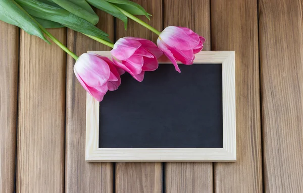 Pink tulips with empty blackboard — Stock Photo, Image