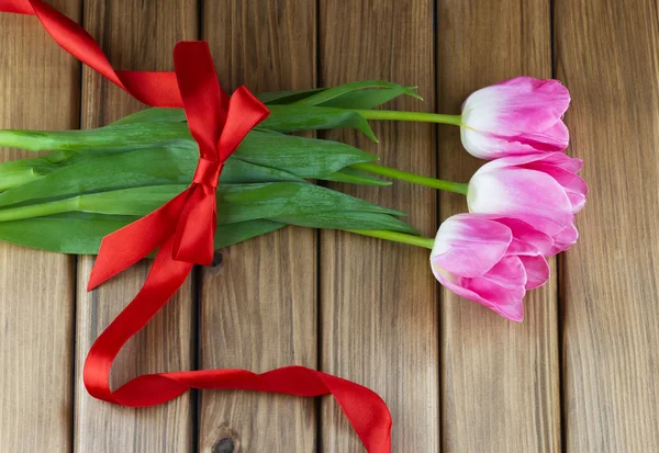 Vue du dessus des tulipes roses avec ruban rouge et arc — Photo