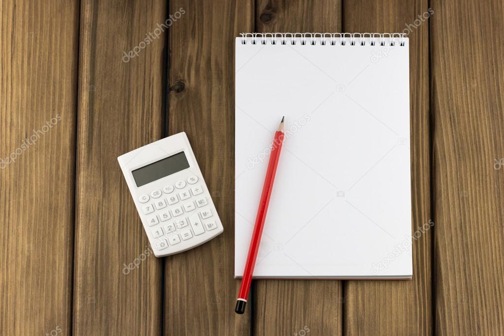 White calculator, notepad and red pencil