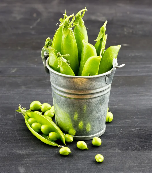 Frische grüne Erbsen im Metalleimer — Stockfoto