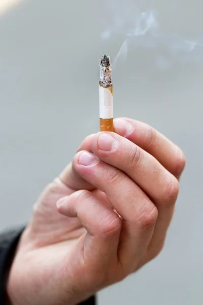 Man hold burning cigarette in hand — Stock Photo, Image