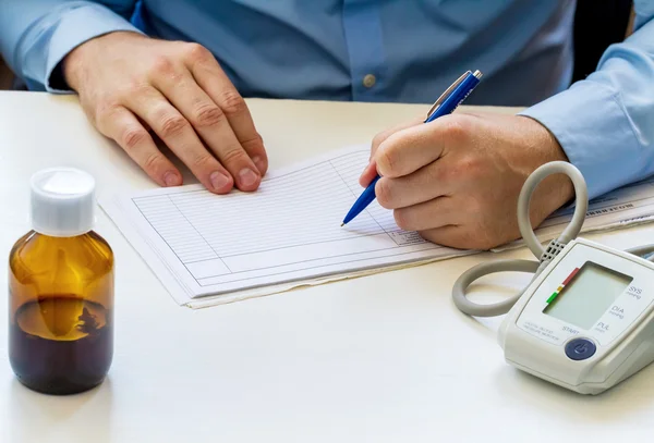 Médico sentado na mesa branca — Fotografia de Stock