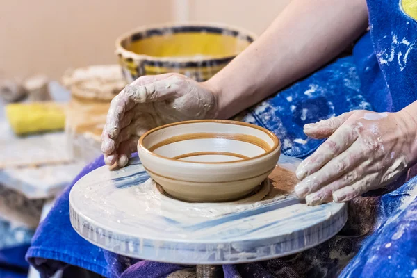 Female hands with clay plate — Stock Photo, Image