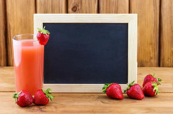 Glass of strawberry juice with blank blackboard — Stock Photo, Image