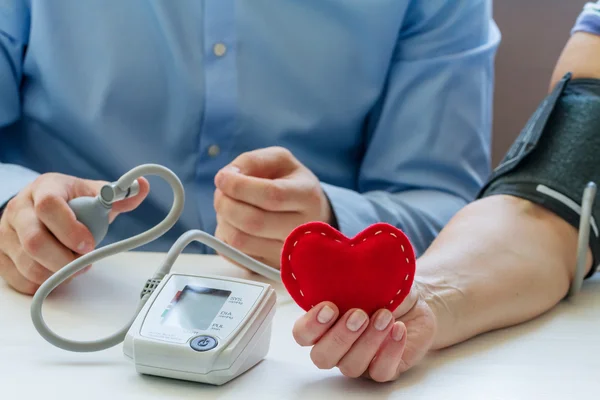 Doctor measuring blood pressure — Stock Photo, Image