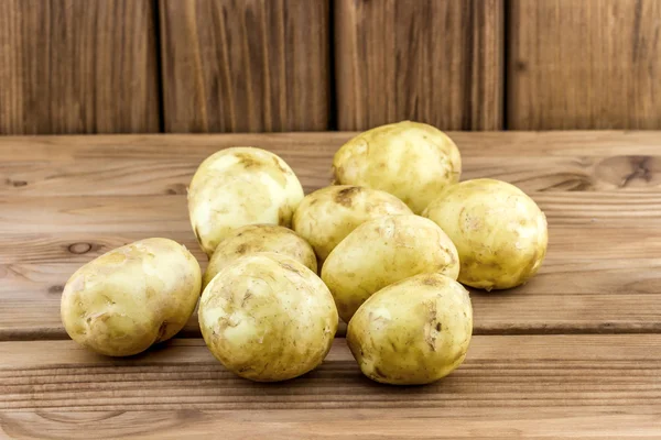 Patatas con cáscara sobre fondo de madera — Foto de Stock