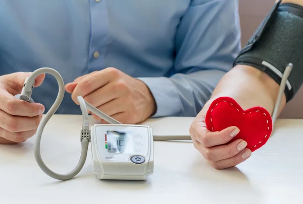 Doctor measuring blood pressure — Stock Photo, Image