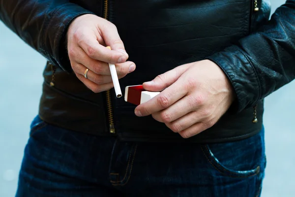 Człowiek posiada palenie papierosa w ręku — Zdjęcie stockowe