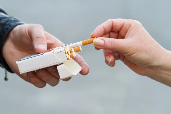 Mano femenina tomar un cigarrillo — Foto de Stock