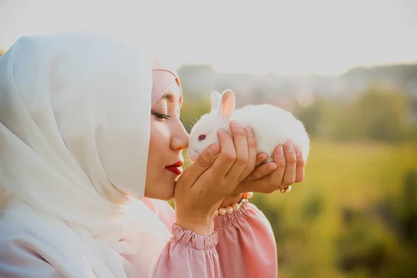 Μουσουλμάνα Γυναίκα Κρατάει Ένα Μικρό Άσπρο Κουνέλι Στην Αγκαλιά Της — Φωτογραφία Αρχείου