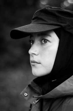 Siyah şapkalı, modaya uygun Müslüman bir kadın. Moda endüstrisi. Yüzü. Kapatın. Siyah beyaz fotoğraf.