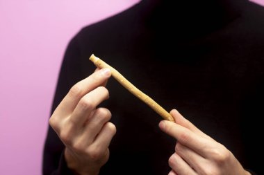 Adam yanlış adamı tutuyor. Bokeh etkisi. Diş temizliği. Sunnah. Sivak. Pembe arkaplan.