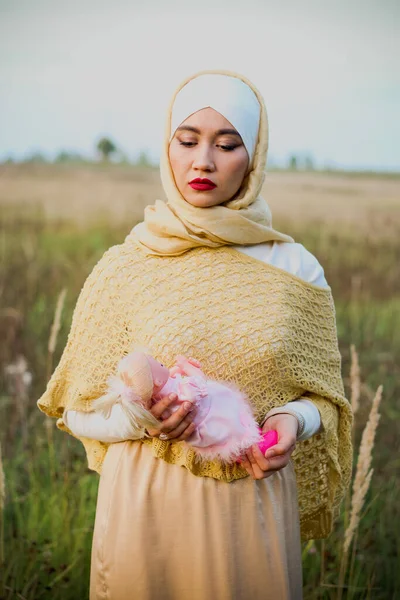 Müslüman Bir Kadın Sahada Duruyor Elinde Bir Bebek Tutuyor Bej — Stok fotoğraf