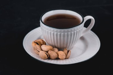 Siyah arka planda beyaz bir tabakta yer fıstığı