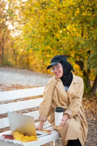 Een Moslimvrouw Een Hijab Een Beige Regenjas Zit Een Bankje — Stockfoto