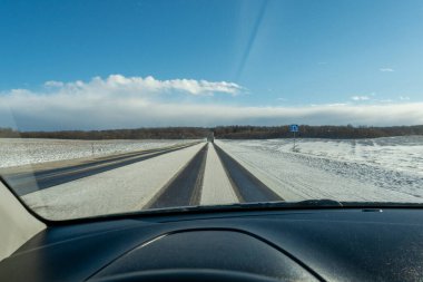 Kar yağışı sırasında karlı otoyol ve güçlü rüzgar. Kamyon kış yoluna çıkıyor. Arabanın ön camından yol manzarası var. Baharın başında güneşli bir gün. Arabanın iç tarafındaki bozulma.