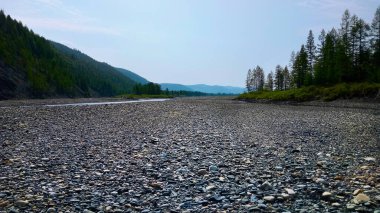Kuru bir dağ nehrinin kayalık dibi. Dağlık bölgede bulutlu bir gün. Doğa arkaplanı