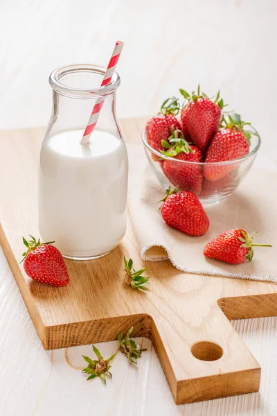 Milk and strawberry on white wooden background — Stock Photo, Image