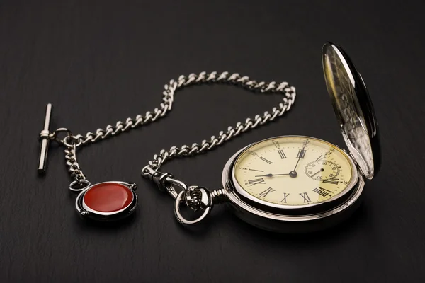 Stylish retro pocket watch on black slate — Stock Photo, Image