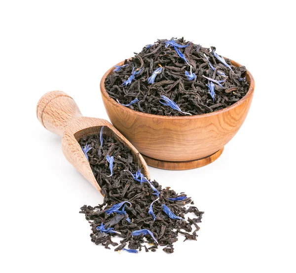 Чай черный с голубыми лепестками в деревянной миске, изолированные на белом Лицензионные Стоковые Изображения