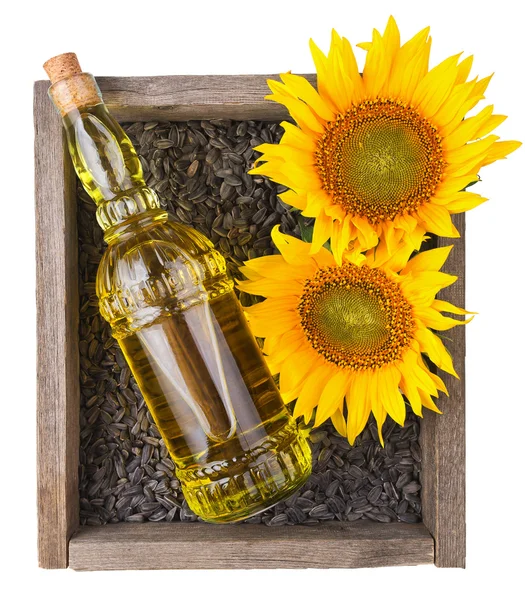 Alten rauhen Holzkiste mit Sonnenblumen, Öl-Flasche und Samen — Stockfoto