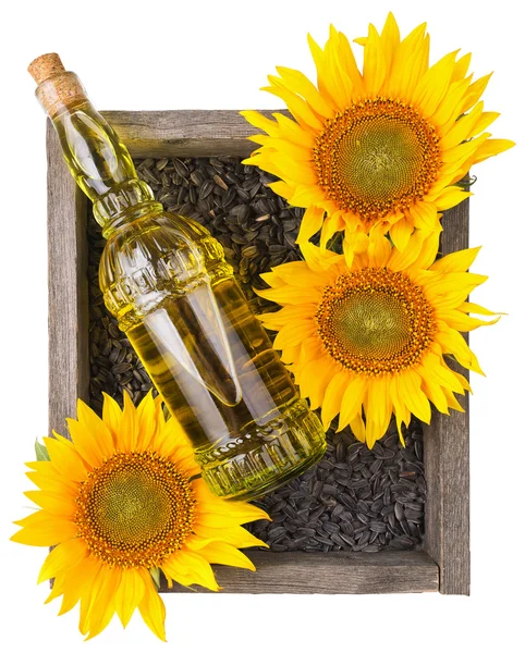 Alten rauhen Holzkiste mit Sonnenblumen, Öl-Flasche und Samen — Stockfoto