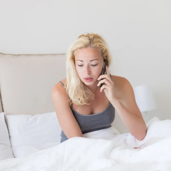 Femme parlant par téléphone au lit le matin . — Photo