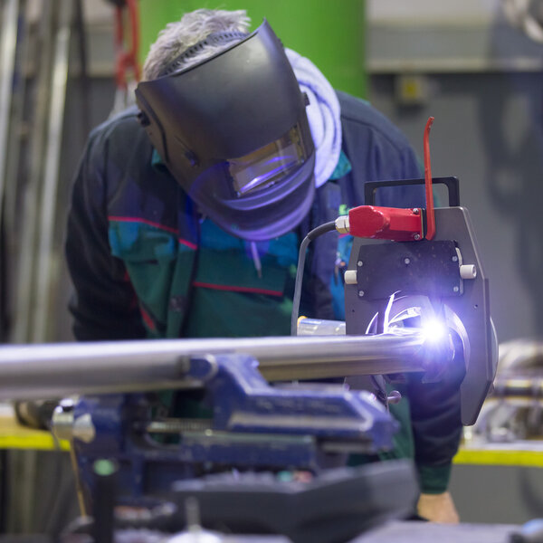 Industrial worker setting orbital welding machine.