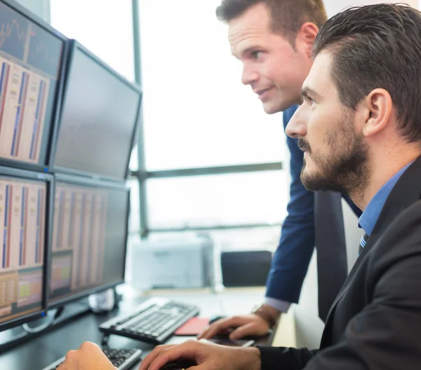 Stock handelaren kijken naar computerschermen. — Stockfoto