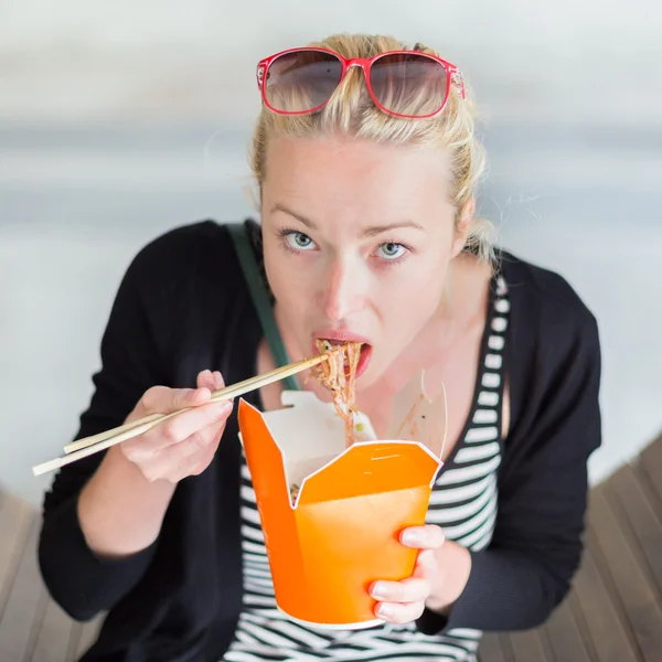 Mujer comiendo noodelos chinos para llevar . — Foto de Stock