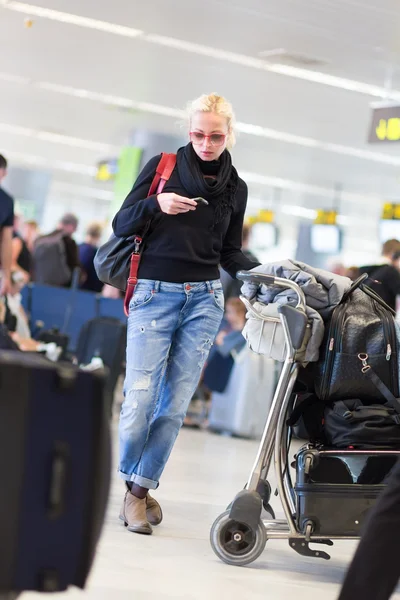 Женщина-путешественница с помощью мобильного телефона во время ожидания в аэропорту . — стоковое фото