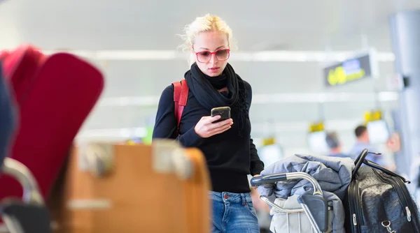 Reisende benutzt Handy beim Warten auf Flughafen. — Stockfoto