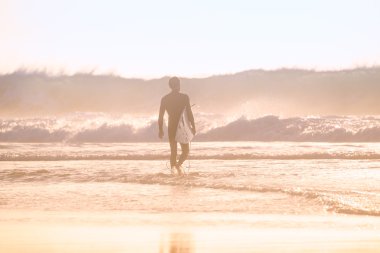 Sörfçü surfboard ile plajda silüeti.