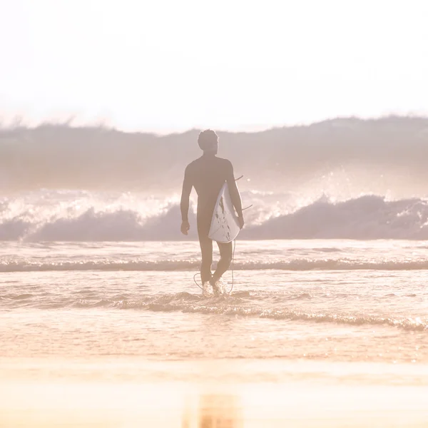 Silhouette eines Surfers am Strand mit Surfbrett. — Stockfoto