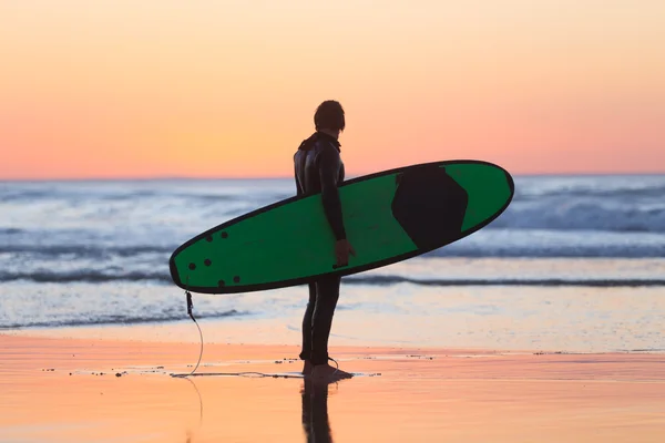 Silueta de surfista en playa con tabla de surf . —  Fotos de Stock