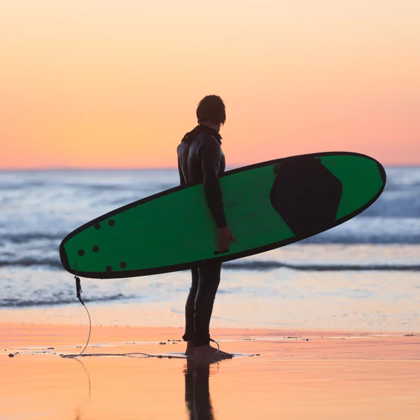 Silhouette eines Surfers am Strand mit Surfbrett. — Stockfoto